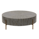 Round bone inlay coffee table with bold black and white stripe geometric top, three brass hairpin legs, side view