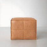 Light brown square leather pouf ottoman, front view, four-panel seamed surface, white background