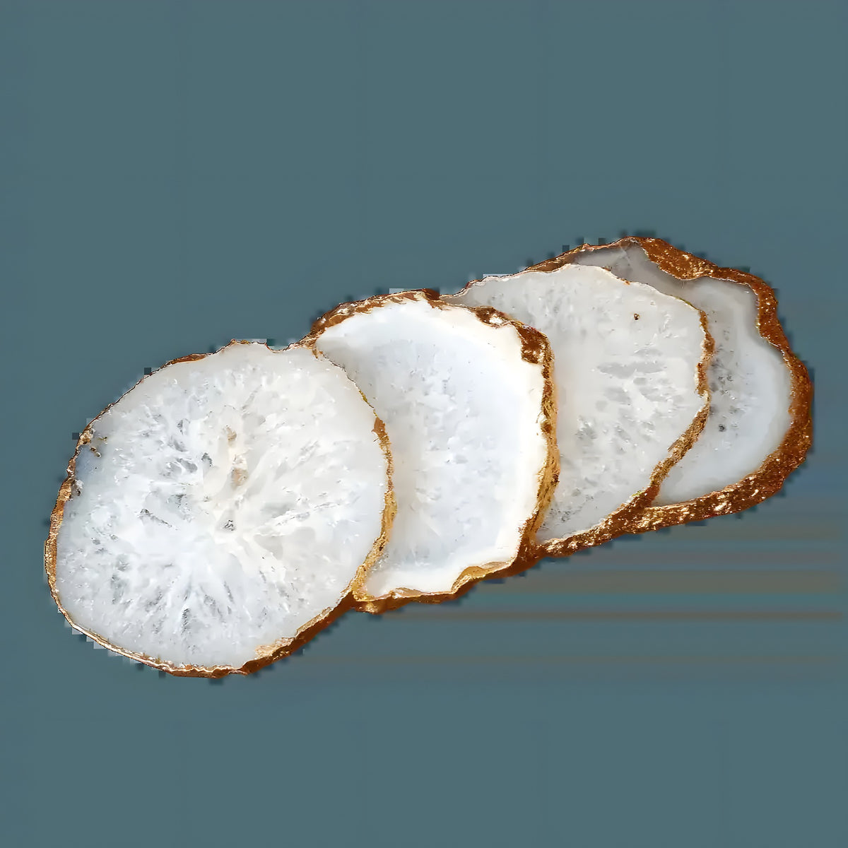 Four white agate geode coasters fanned diagonally showing gold-leaf jagged edges on grey