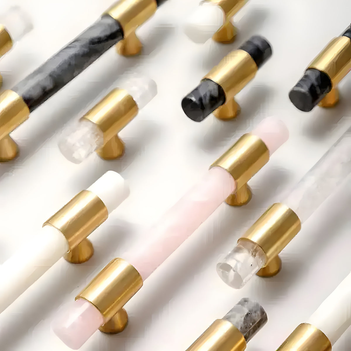 Multi-colorway marble brass cabinet handles in black, grey, pink, white flat-lay on white surface