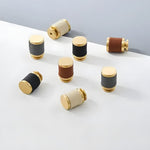 7 brass leather cabinet door knobs scattered on white surface in black, brown, and cream