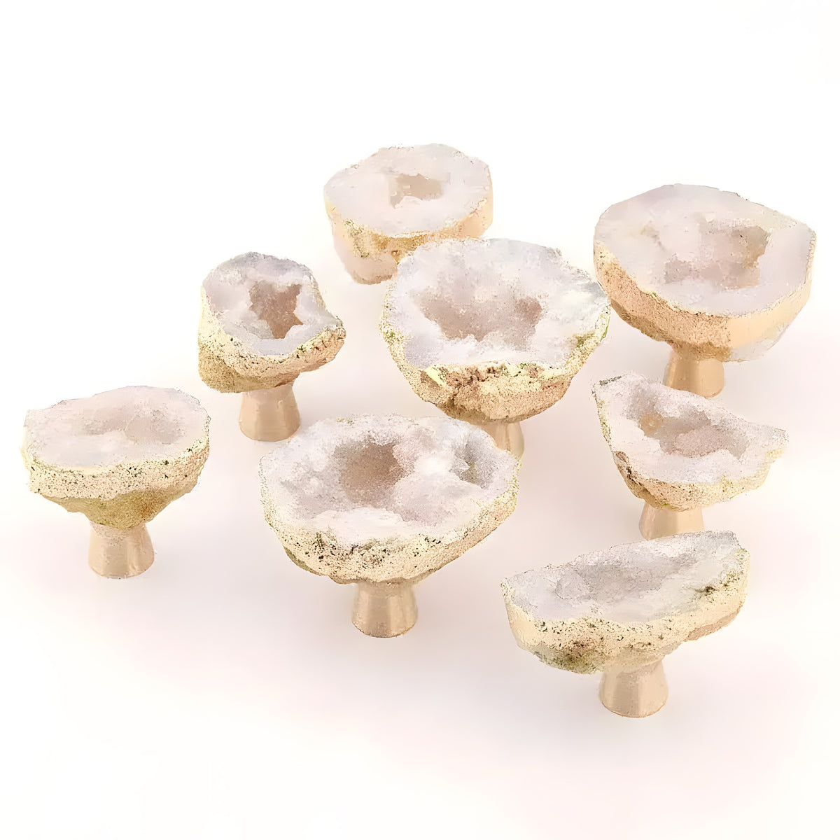 Nine natural crystal geode cabinet knobs on brass stems, white druzy tops with gold-gilded rough edges, group shot