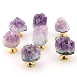 Six natural amethyst crystal cluster drawer knobs on polished gold bases from multiple angles on white
