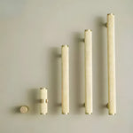 Five textured knurled brass cabinet pulls in graduated sizes from round knob to long bar pull on beige background