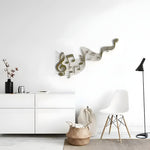 Gold wavy music staff with treble clef on white wall in minimalist room with white TV cabinet and modern chair