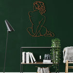 Copper line-art diva woman silhouette seated with back turned, dark green wall above open metal shelf with ivy