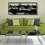 Black framed San Francisco skyline metal wall art with Bay Bridge silhouette, above olive green sofa in living room