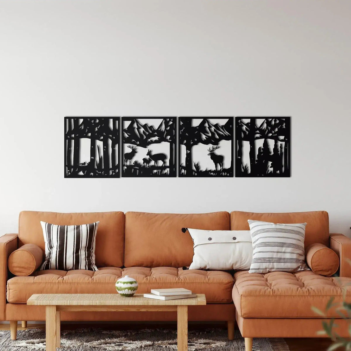 4-panel deer family metal wall art in black — antlered deer and fawn in forest with mountains, above leather sofa