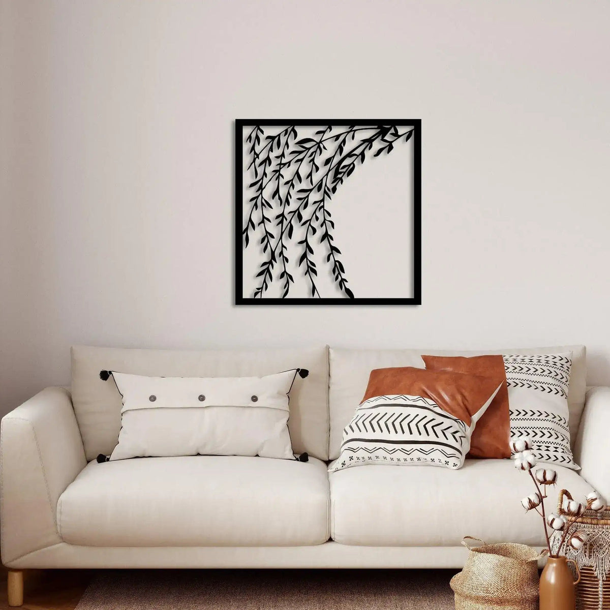 Leafy Branch Metal Wall Decor black framed square panel with cascading branches above boho sofa