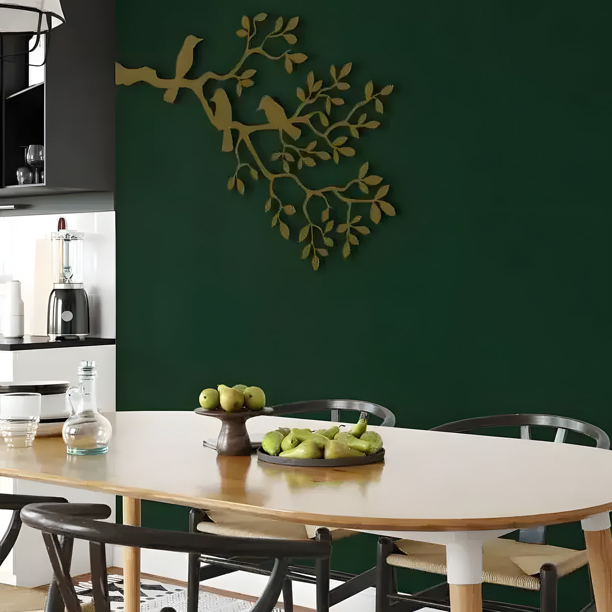 Gold birds-on-branch metal wall decor on dark green dining room wall above wooden table
