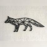 Black geometric fox metal wall art in walking profile, triangular polygon cutouts on white textured wall