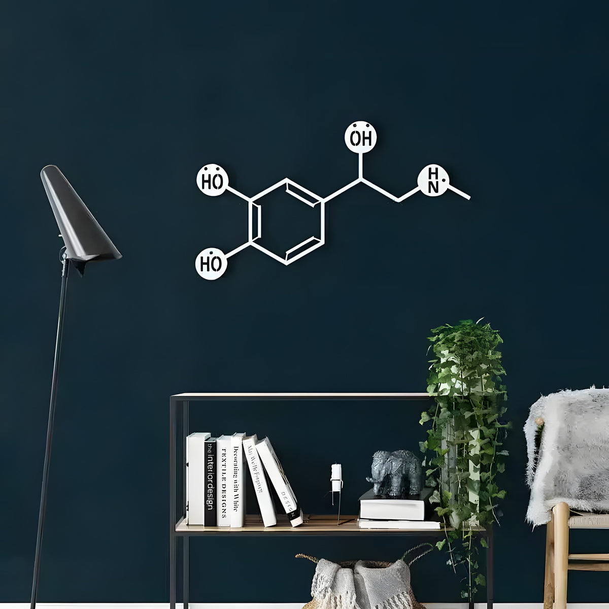 White adrenaline molecule metal wall art with labeled atom nodes on dark navy wall above modern shelf with books