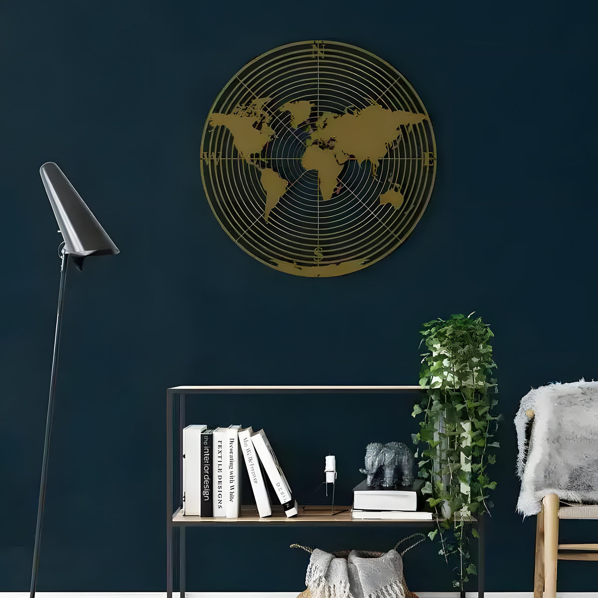 Gold round world map continents wall art on dark teal wall above bookshelf in room setting