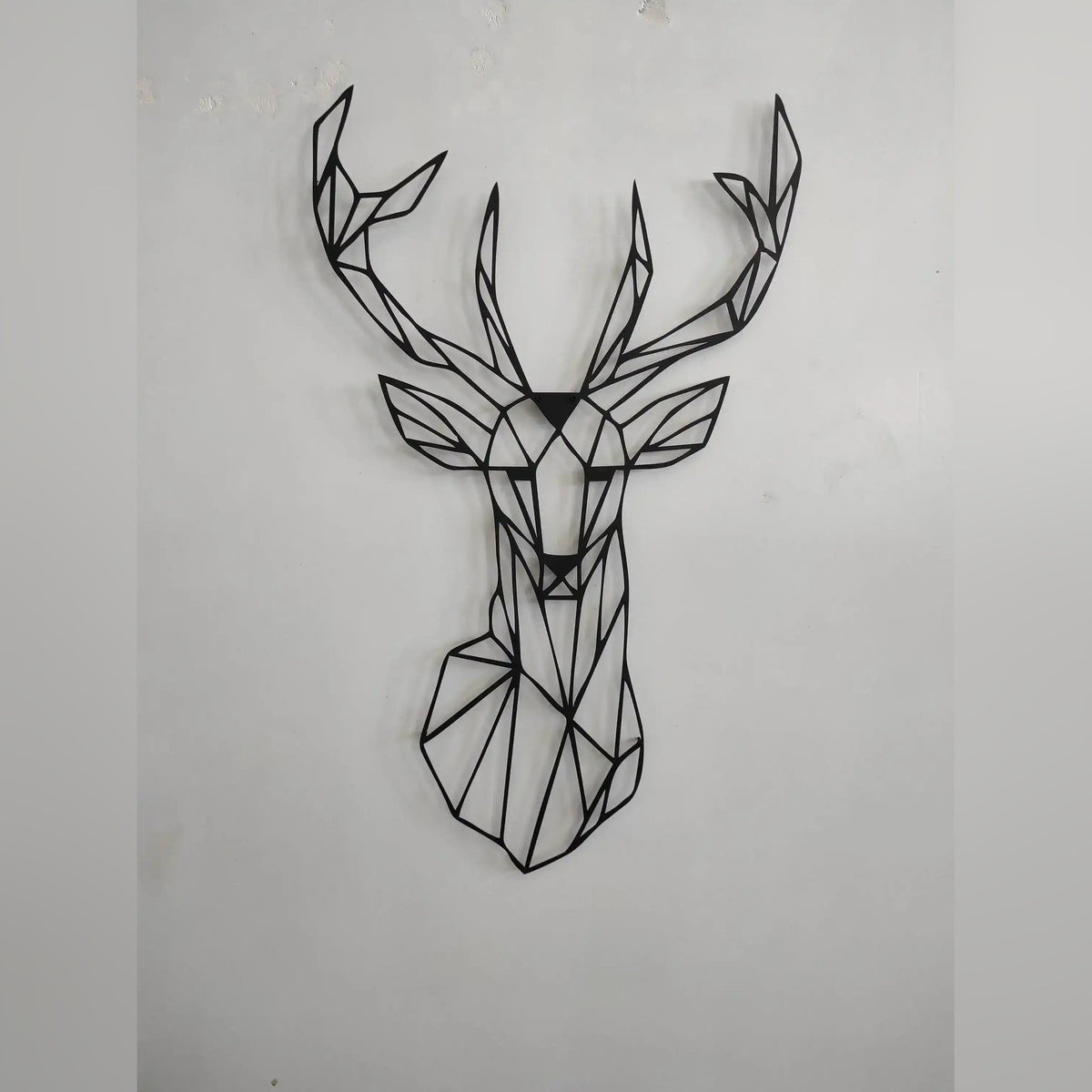 Geometric Deer Head Metal Wall Art with angular polygon facets on dark wall beside staircase