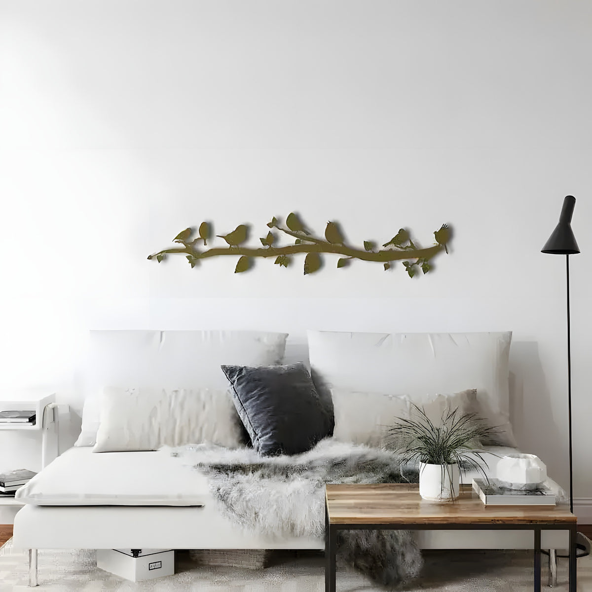 Gold birds on tree branch wall art above white sofa, horizontal leafy branch with perched birds