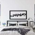 Flying Birds Metal Wall Art in black frame above bed — flock of birds mid-flight silhouettes in panoramic framed art, modern bedroom