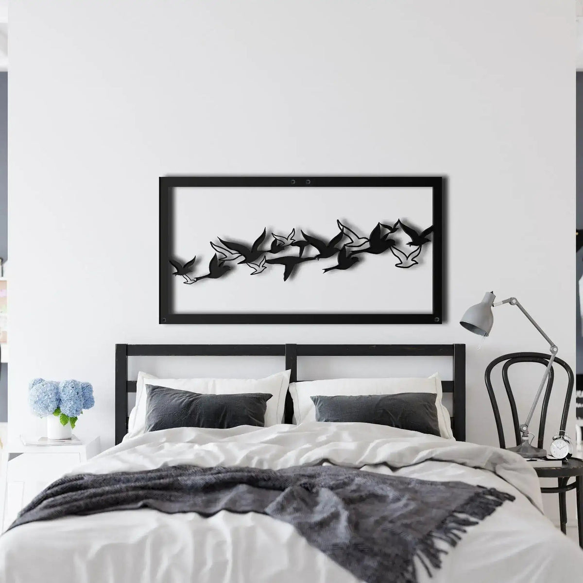 Flying Birds Metal Wall Art in black frame above bed — flock of birds mid-flight silhouettes in panoramic framed art, modern bedroom