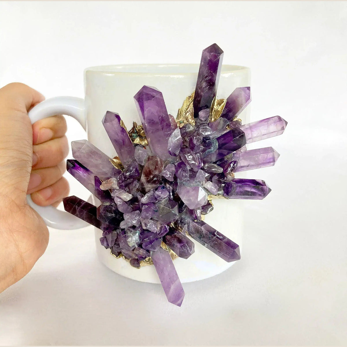 White ceramic amethyst crystal mug with large cluster of purple pointed crystal spires on front, white handle