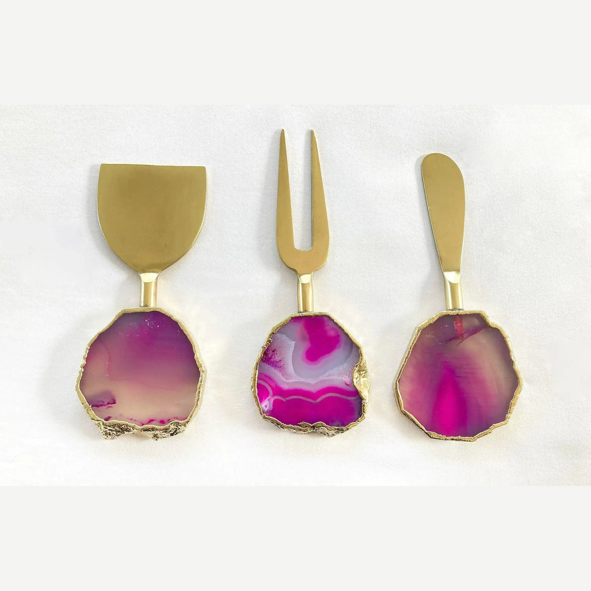 Three silver pink agate cheese knives flat lay on grey, blush translucent agate handles, silver jagged edges
