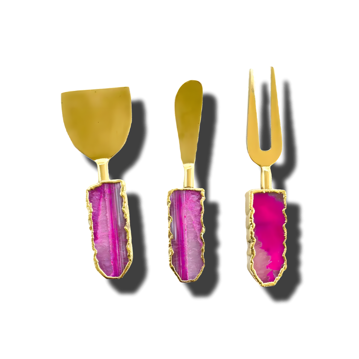 Three pink agate cheese knives with gold blades, vibrant magenta agate handles with gold-trimmed edges, front view on gray