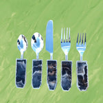 Five-piece amethyst cutlery set on green background, silver spoons, knife and forks with dark banded agate handles, overhead