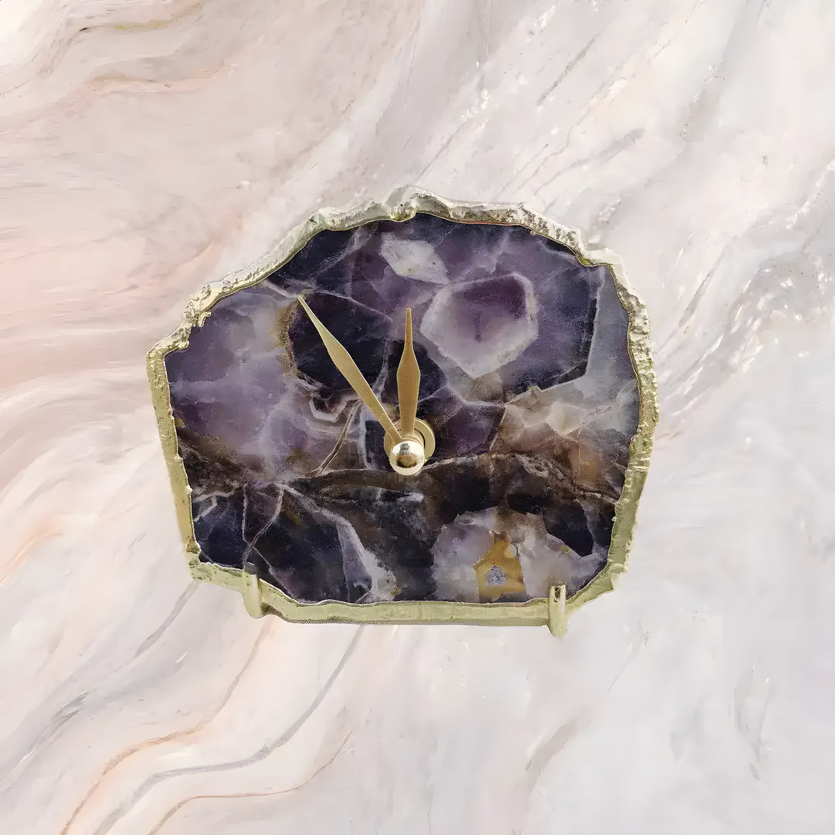 Overhead view of amethyst desk clock with irregular purple crystal stone face, gold rough-edge bezel and gold hands