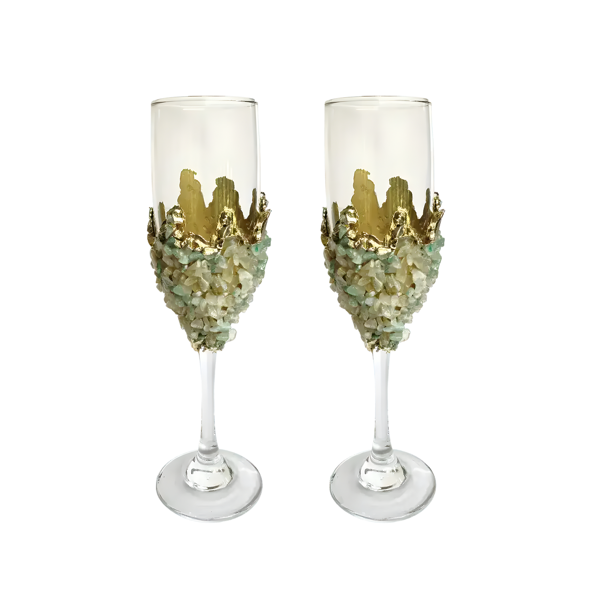 Two tall champagne flutes adorned with light green quartz chips clustered around the lower bowl, topped with gold crown-like embellishment