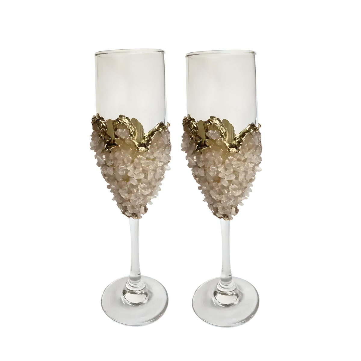 Two tall rose quartz champagne flutes with blush chip-encrusted bowl and gold wave crown rim, clear stem and base on white
