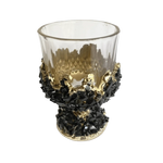 Black quartz wine glass — faceted clear upper bowl, black quartz chips with gold banding, chunky quartz base on white