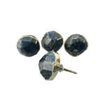 Four pyrite gemstone agate cabinet knobs with dark charcoal faceted stone faces and gold rims, one showing mounting screw