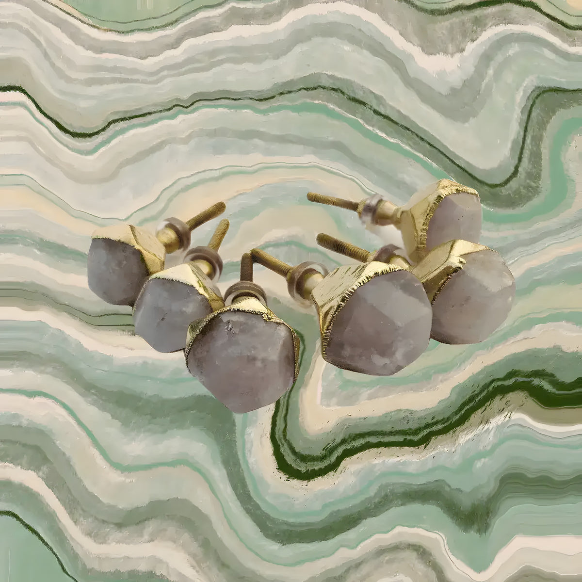 Four rose quartz round faceted pulls with gold-cap frames and threaded stems, clustered on green banded onyx marble surface