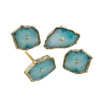 Four freeform aqua-teal agate cabinet knobs with jagged gold bezels and central gold studs on white, one showing screw post