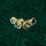 Two moss green agate cabinet pull knobs with faceted stone and raw gold-leafed setting on a swirling malachite-patterned background
