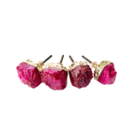 Four vivid magenta-pink raw agate cabinet pulls in a row with gold top caps and threaded stems, on grey background