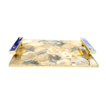 Angled view of brown plated agate tray, cream and grey agate mosaic top in gold frame with two purple onyx stone bar handles