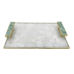 Angled view of white crystal agate serving tray, white crystal agate stone mosaic surface, gold frame and two teal green agate bar handles