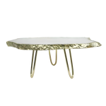 White agate cake stand side view with organic agate slab top, gold-plated jagged edge and three gold hairpin legs