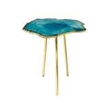 Vivid teal-blue organic edge accent table — single large round blue agate slice with concentric darker center, serrated gold rim, three gold legs