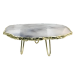 Grey agate quartz cake stand, oval translucent smoky grey-white agate slab with jagged gold rim on three hairpin brass legs