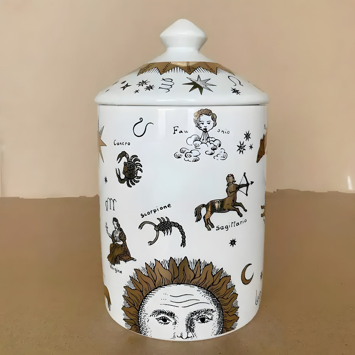 White ceramic gold-gilded zodiac sign candle jar with domed lid, decorated with etched Sagittario, Cancro, Vergine and sun face illustrations