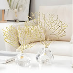 Two gold brassed fan coral sculptures on clear acrylic stands, living room table setting