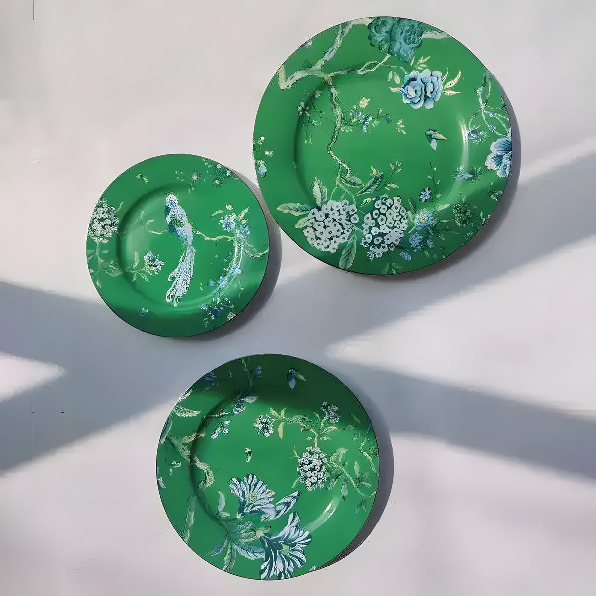 Jade phoenix floral dinnerware three plates overhead on white, emerald green with blue phoenix and floral motifs