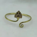 Recycled brass Naga bangle open cuff with engraved leaf hood motif and spiral curl end, gold tone, white background