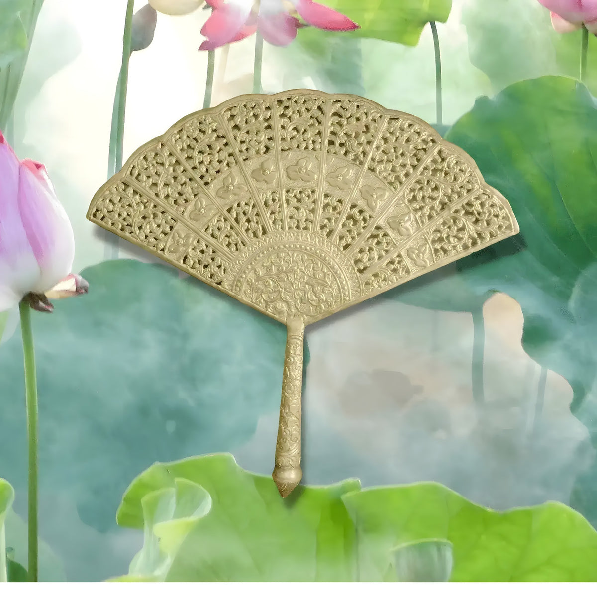 Gold brass decorative fan with intricate pierced floral engravings against misty lotus flower background