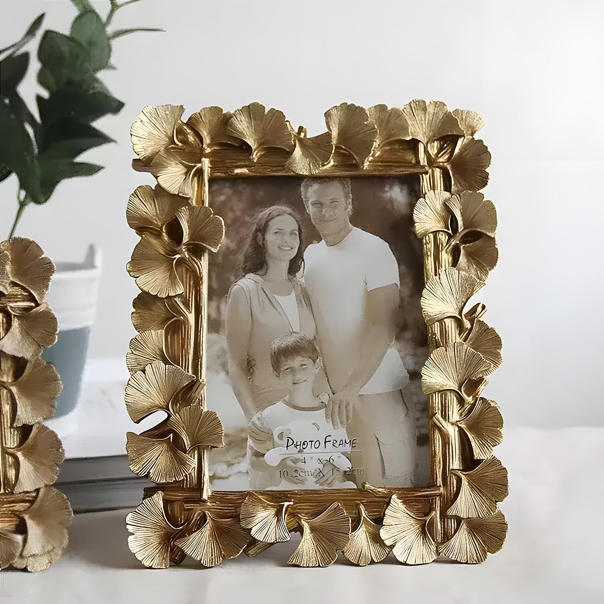 Brass Ginkgo Leaf Photo Frame in antique gold with embossed leaf clusters surrounding a 4-inch family portrait