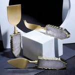 Rose Quartz Cheese Knives set of 3 with raw pink quartz handles and gold-tone blades, arranged on white geometric props