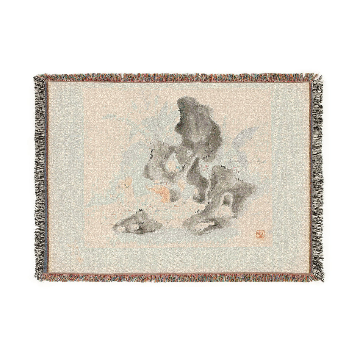 A rectangular woven throw blanket with fringed edges, featuring a minimalist ink-style illustration of rocks and clouds in soft gray, beige, and muted blue tones on a light cream background.