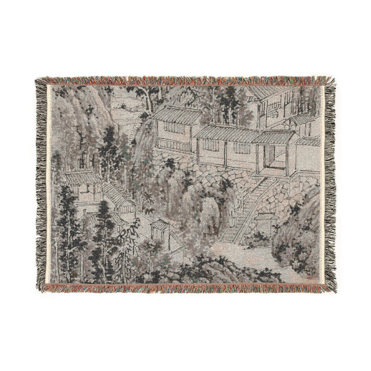 A rectangular woven throw blanket featuring a detailed landscape print in muted gray, beige, and brown tones, with multicolor fringed edges, shown flat against a white background.