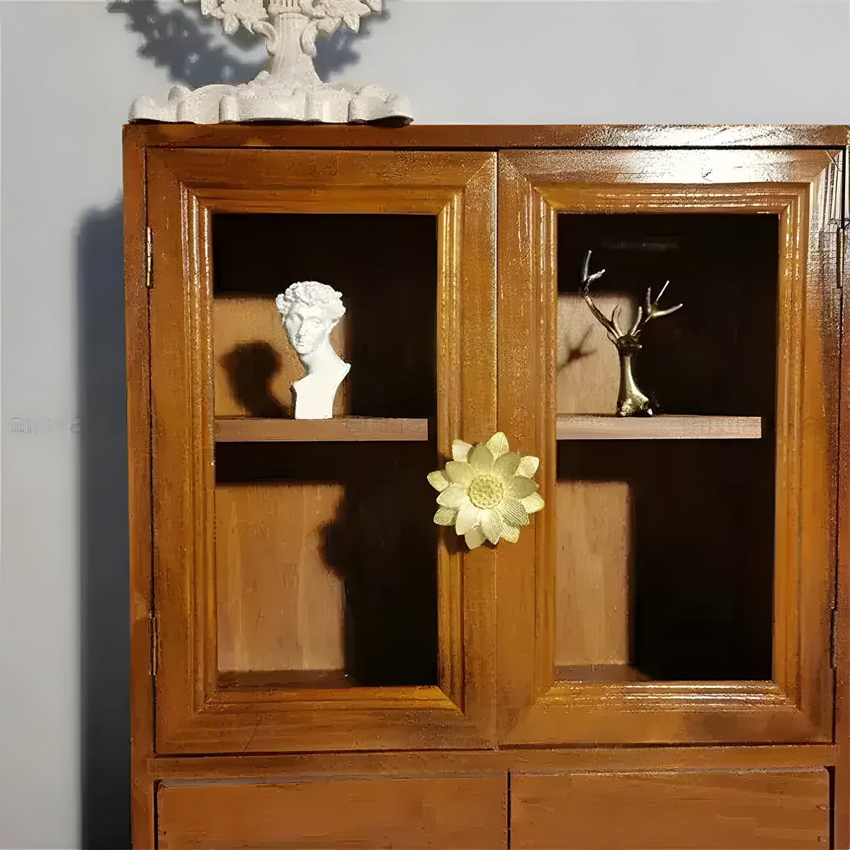 Gold brass lotus floral cabinet knob on double-door wooden display cabinet with glass panels