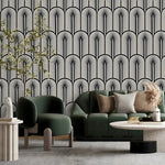 Monochrome Deco Elegance wallpaper of arched fan motifs in black and cream behind a green sofa